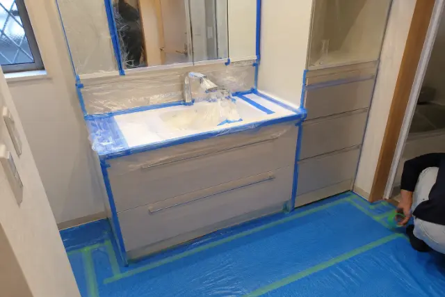 洗面所まわりを丁寧に養生する作業